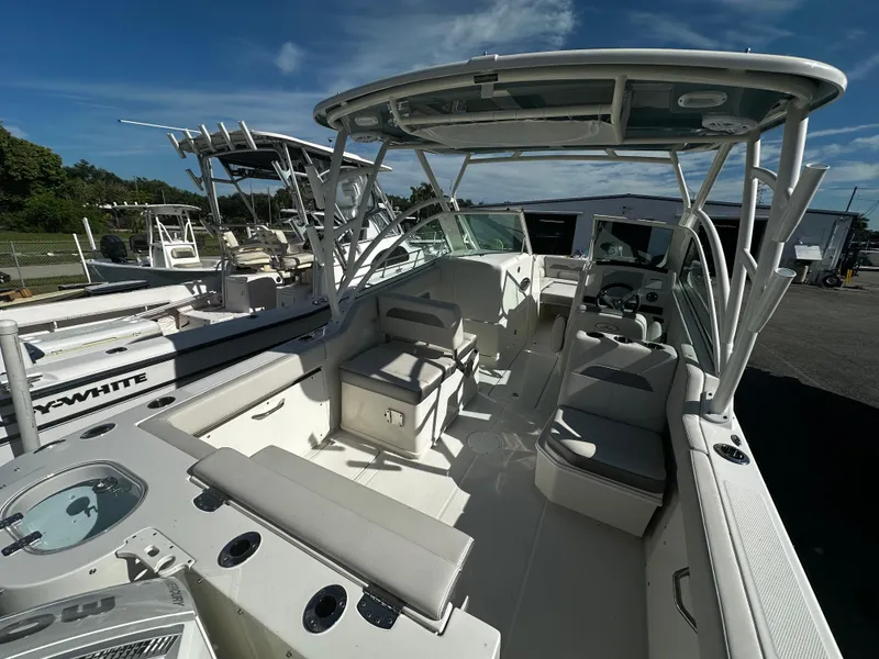 Slide: The Image of 2025 Sailfish 245 DC boat interior with seating and helm under a clear sky. - 7