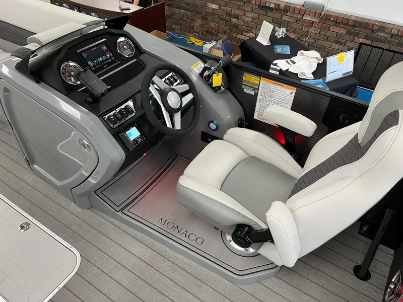 Slide: The Image of 2025 Godfrey Monaco 235 RL boat cockpit with modern steering console and comfortable captain's chair. - 17