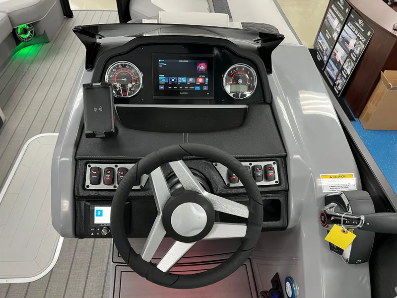 Slide: The Image of 2025 Godfrey Monaco 235 RL boat dashboard with steering wheel and digital display. - 18
