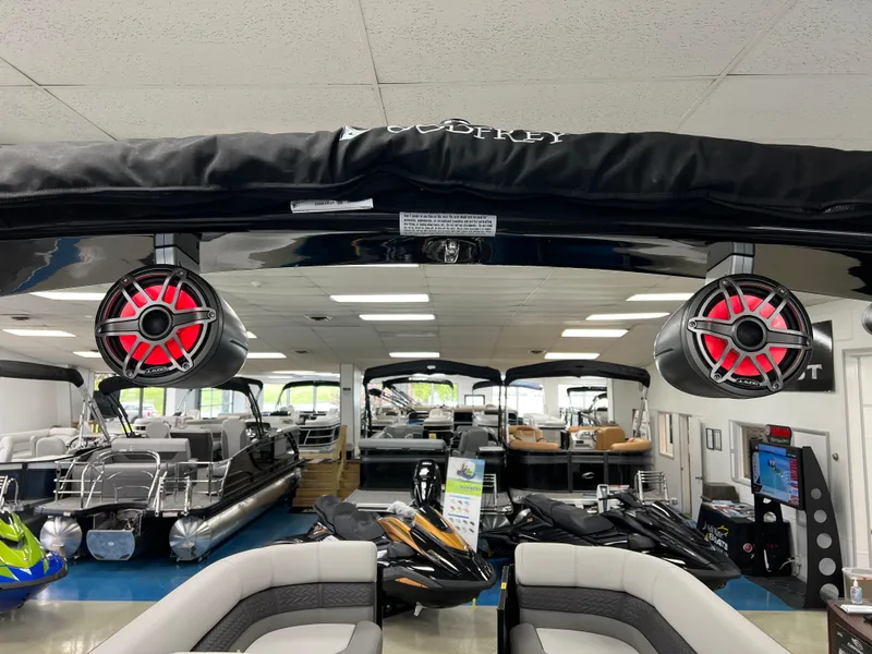 Slide: The Image of 2025 Godfrey Monaco 235 RL pontoon boat in showroom with red speakers. - 25