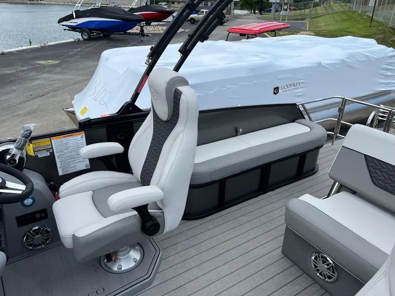 Slide: The Image of 2025 Godfrey Monaco 235 RL pontoon boat interior with captain's chair and seating. - 12