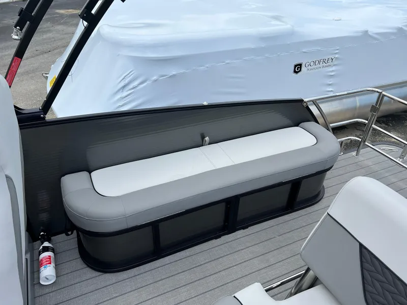 Slide: The Image of 2025 Godfrey Monaco 235 RL boat with gray seating and covered deck. - 14