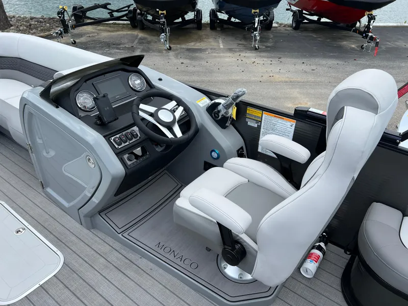 Slide: The Image of 2025 Godfrey Monaco 235 RL boat cockpit with steering wheel and captain's chair. - 20