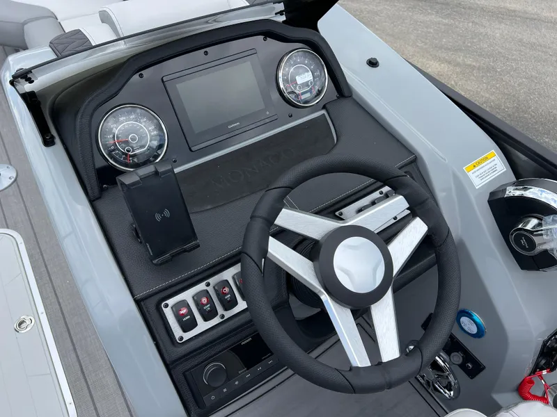 Slide: The Image of 2025 Godfrey Monaco 235 RL boat dashboard with steering wheel, gauges, and control panel. - 21