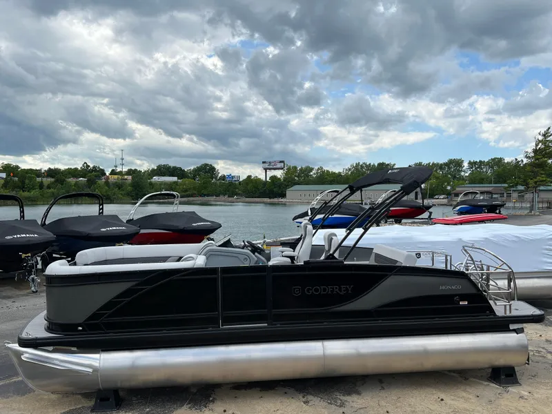 Slide: The Image of 2025 Godfrey Monaco 235 RL pontoon boat docked by the lake. - 3