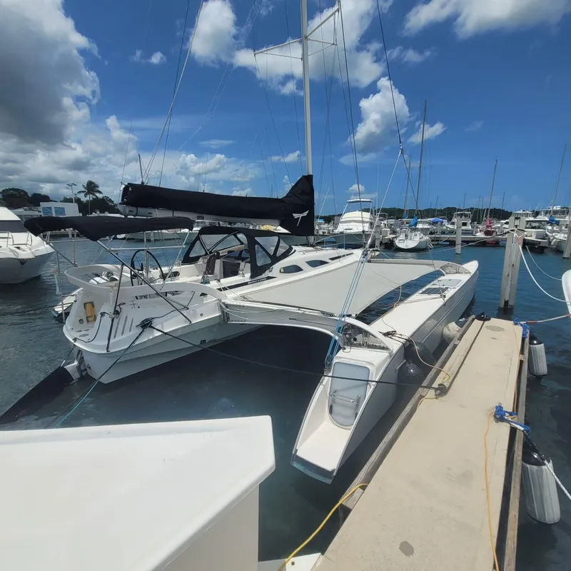 Slide: The Image of 2007 Dragonfly 35 Ultimate trimaran docked at marina under blue sky. - 2