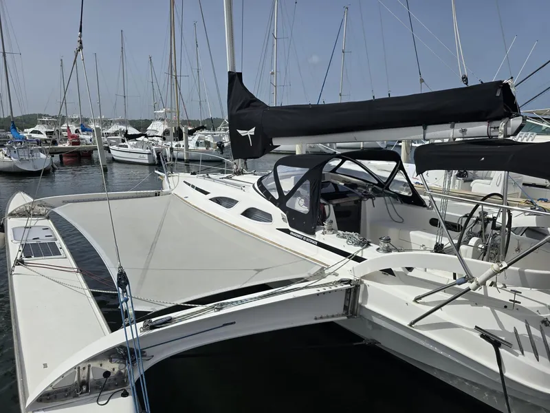 Slide: The Image of 2007 Dragonfly 35 Ultimate trimaran docked in a marina, surrounded by other sailboats. - 5