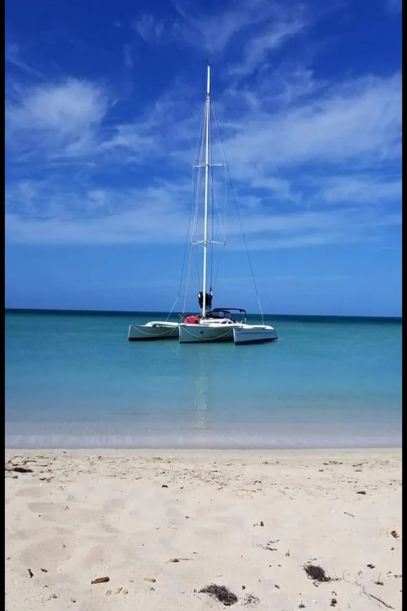 Slide: The Image of Sailboat Dragonfly 35 Ultimate 2007 anchored near a sandy beach under a clear blue sky. - 7