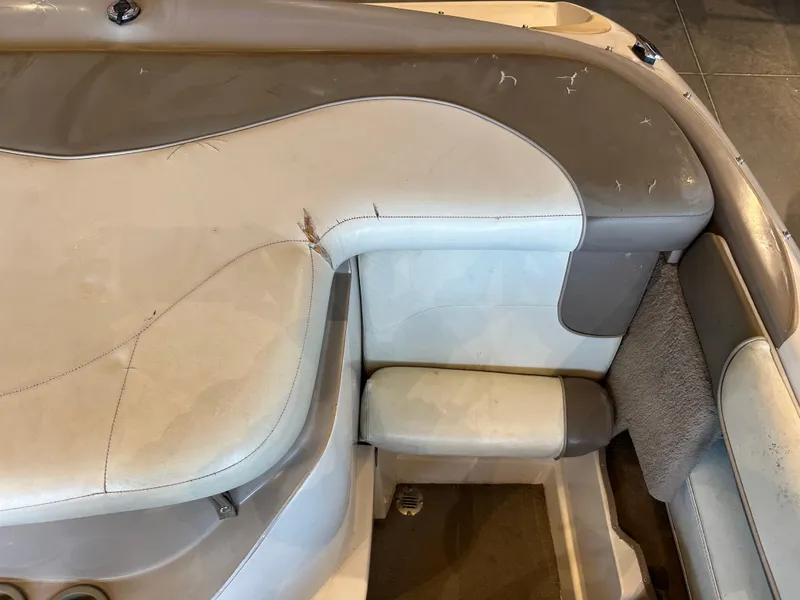 Slide: The Image of Interior seating of a 2001 Tahoe Q5 boat, featuring beige and gray upholstery. - 11