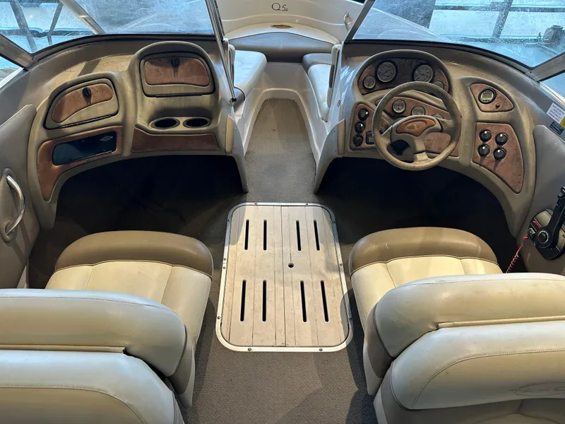 Slide: The Image of Interior of a 2001 Tahoe Q5 boat with beige seating and wooden dashboard. - 13