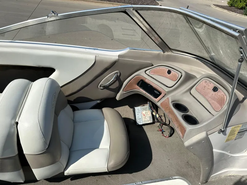 Slide: The Image of 2001 Tahoe Q5 boat interior with beige and white seating, dashboard, and cup holders. - 5