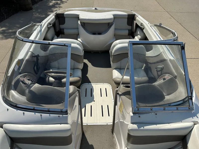 Slide: The Image of 2001 Tahoe Q5 boat interior with seating and windshield, parked on concrete. - 7