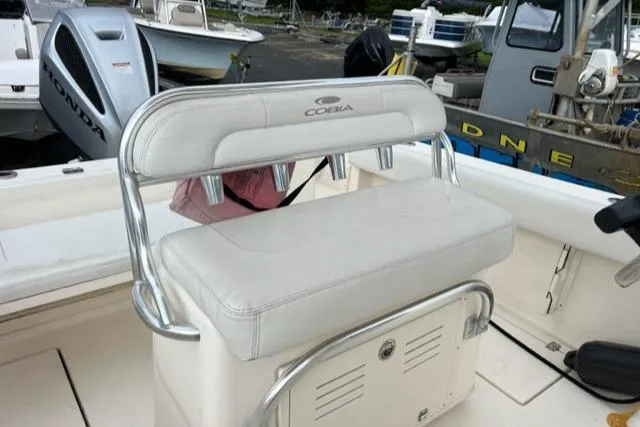 Slide: The Image of 2021 Cobia 237 Center Console boat with cushioned seating and storage compartment. - 13