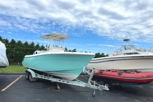 Slide: The Image of 2021 Cobia 237 Center Console boat on trailer under cloudy sky. - 5