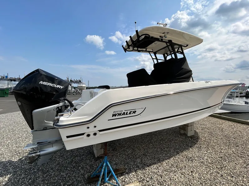 The Image of 2024 Boston Whaler 230 Outrage boat docked by a wooden pier. - 0