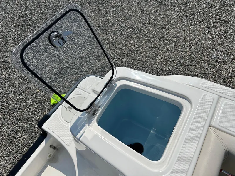 Slide: The Image of 2024 Boston Whaler 230 Outrage interior storage compartment with safety equipment. - 19