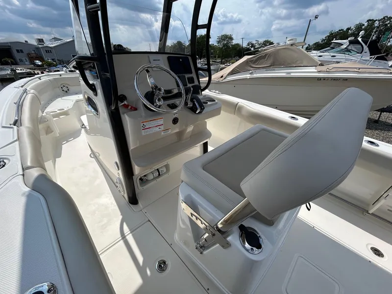 Slide: The Image of 2024 Boston Whaler 230 Outrage boat interior, spacious deck, and seating area. - 9
