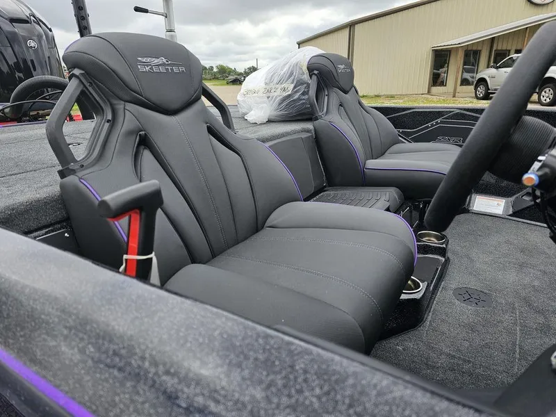 Slide: The Image of 2025 Skeeter ZXR21 boat interior with black and purple seats. - 12