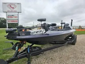 Slide: The Image of 2025 Skeeter ZXR21 fishing boat on trailer, displayed outdoors near dealership signs. - 16