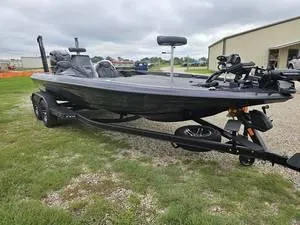 Slide: The Image of 2025 Skeeter ZXR21 bass boat on a trailer, parked on grass. - 26