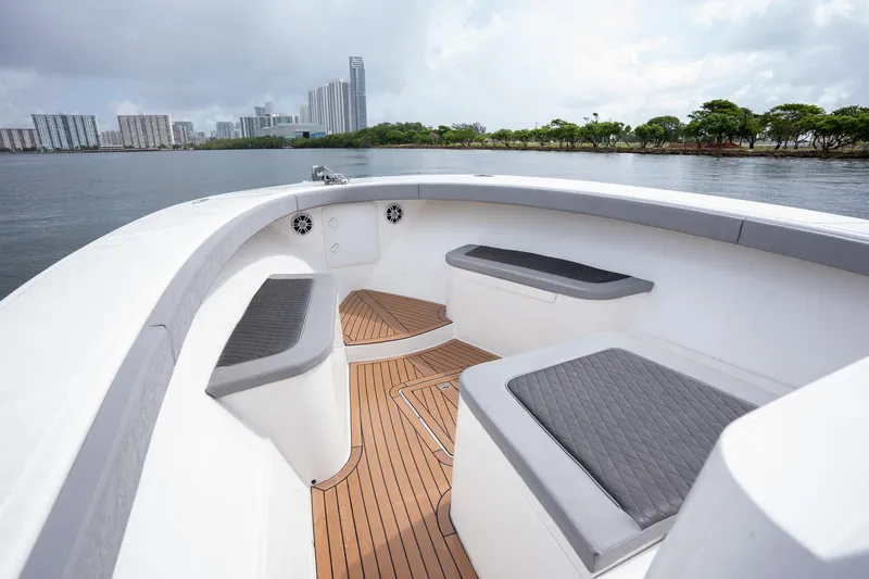 Slide: The Image of 2023 Seahorse 36 CC boat interior with cushioned seating and waterfront city view. - 11