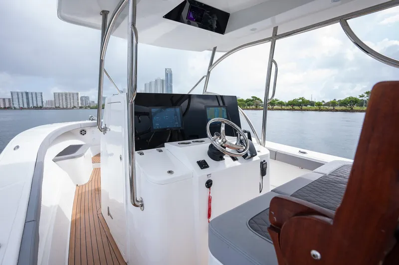 Slide: The Image of 2023 Seahorse 36 CC boat cockpit with modern controls and waterfront view. - 13