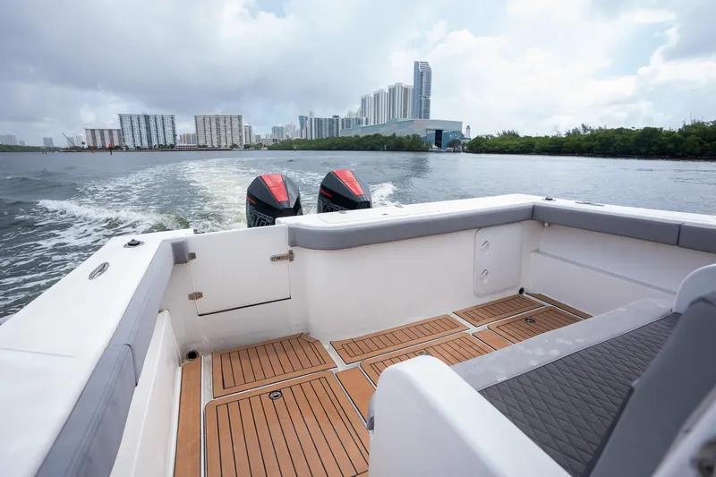 Slide: The Image of 2023 Seahorse 36 CC boat cruising on water with city skyline in background. - 18