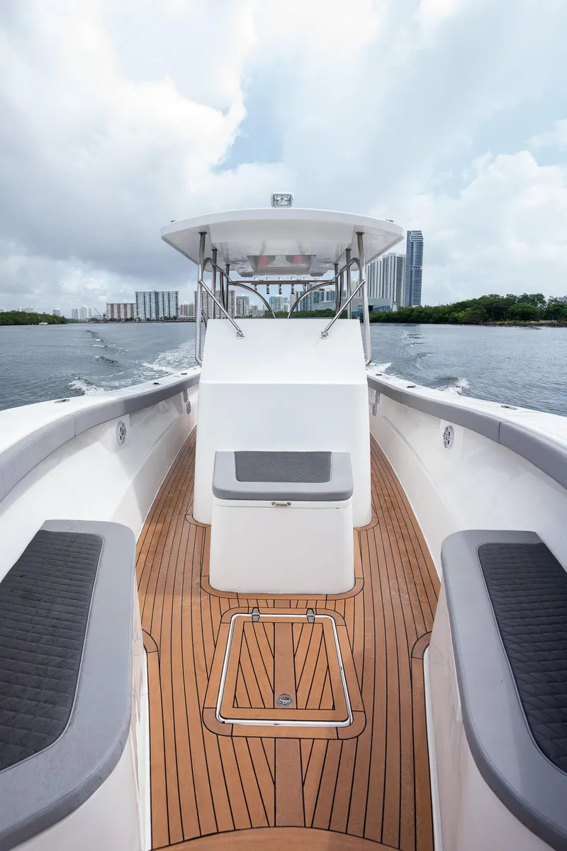 Slide: The Image of 2023 Seahorse 36 CC boat cruising on water, featuring sleek design and wooden deck. - 22
