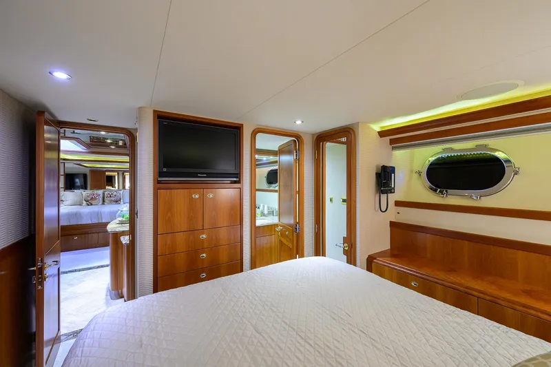 Slide: The Image of Luxurious 2008 Westport 112 yacht bedroom with wood accents and porthole window. - 64