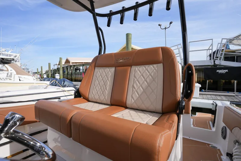 Slide: The Image of Hydra-Sports 2796 Vector 2000 boat with tan and white cushioned seating at marina. - 27