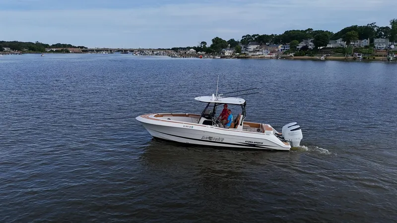 Slide: The Image of 2000 Hydra-Sports 2796 Vector boat cruising on a calm lake near a residential area. - 6