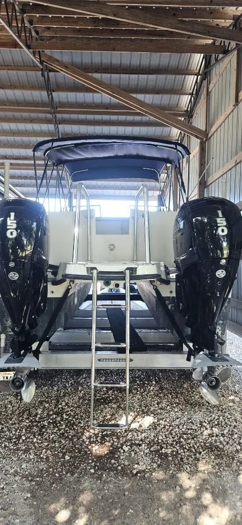 Slide: The Image of 2007 Glacier Bay 2640 Renegade boat with dual outboard motors in a covered storage. - 2