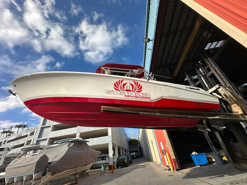 Slide: The Image of 2020 Wellcraft 302 Fisherman boat in dry dock, red and white hull, under a blue sky. - 1