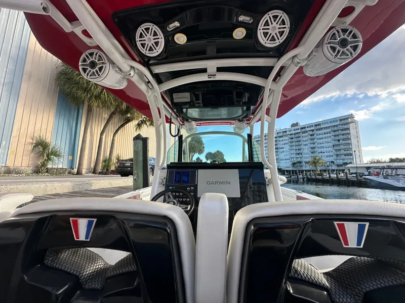 Slide: The Image of 2020 Wellcraft 302 Fisherman boat interior with Garmin display, speakers, and waterfront view. - 10