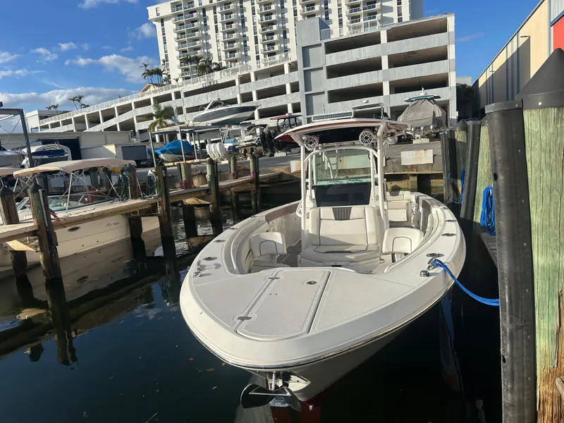 Slide: The Image of 2020 Wellcraft 302 Fisherman boat docked in marina, urban backdrop. - 26