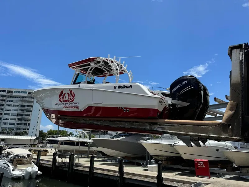 Slide: The Image of 2020 Wellcraft 302 Fisherman boat lifted at marina, clear sky background. - 3