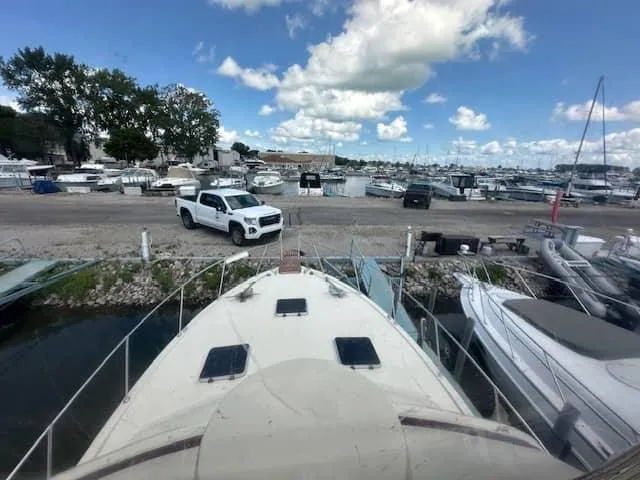 Slide: The Image of 1985 Trojan T36 boat docked at a marina with a white truck in the background. - 17
