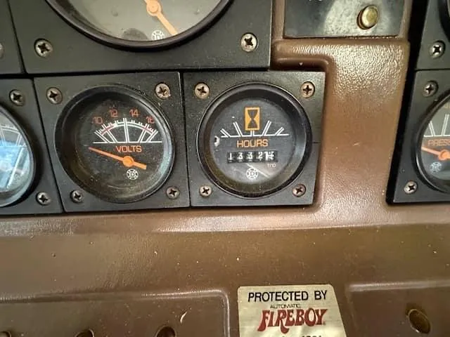 Slide: The Image of 1985 Trojan T36 dashboard with voltmeter and hour meter gauges. - 22
