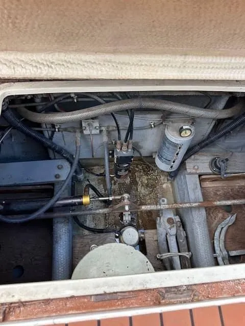 Slide: The Image of 1985 Trojan T36 engine compartment with various mechanical components and wiring. - 25