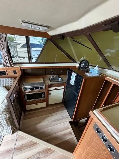 Slide: The Image of 1985 Trojan T36 boat interior kitchen with stove, sink, fridge, and microwave. - 3