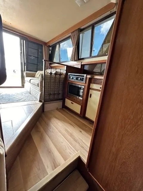 Slide: The Image of Interior of 1985 Trojan T36 motorhome with wooden flooring and built-in kitchen appliances. - 4