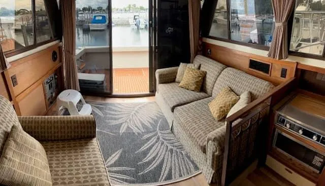 Slide: The Image of Interior of a 1985 Trojan T36 yacht with cozy seating and marina view. - 7