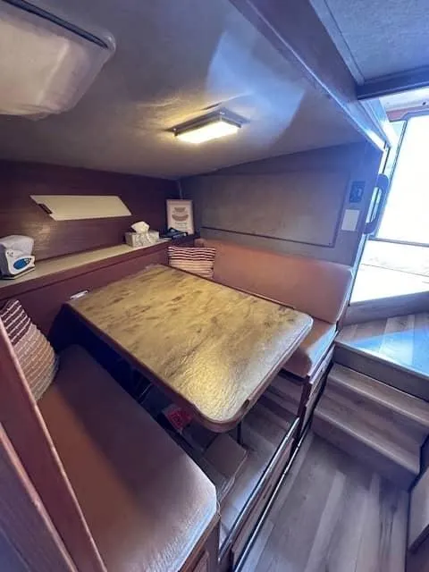 Slide: The Image of 1985 Trojan T36 boat interior dining area with wooden table and cushioned seating. - 8