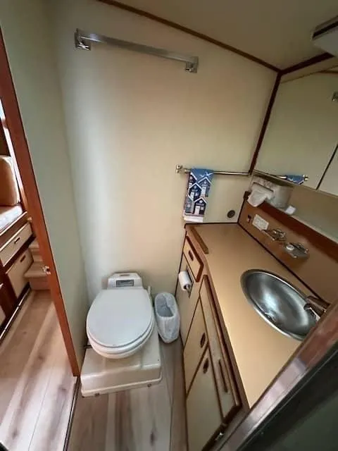 Slide: The Image of 1985 Trojan T36 boat bathroom with toilet, sink, and storage cabinets. - 9