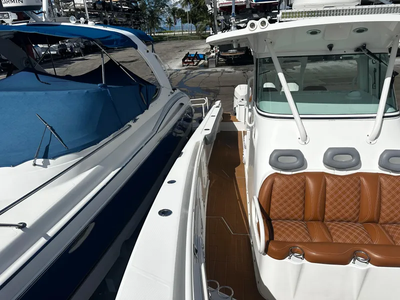 Slide: The Image of 2008 Everglades 350 CC boat docked next to another boat, featuring brown leather seats. - 25