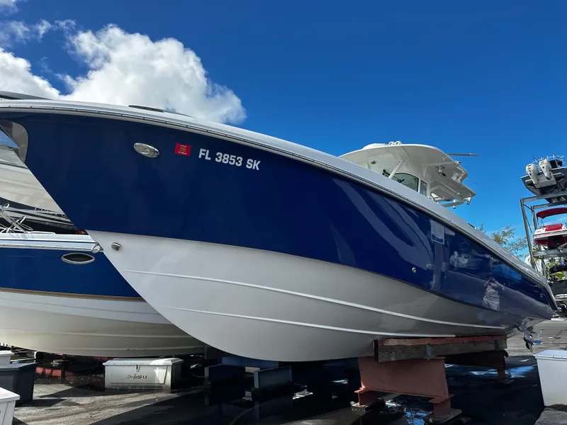 Slide: The Image of 2008 Everglades 350 CC boat in blue and white, docked under a clear sky. - 26