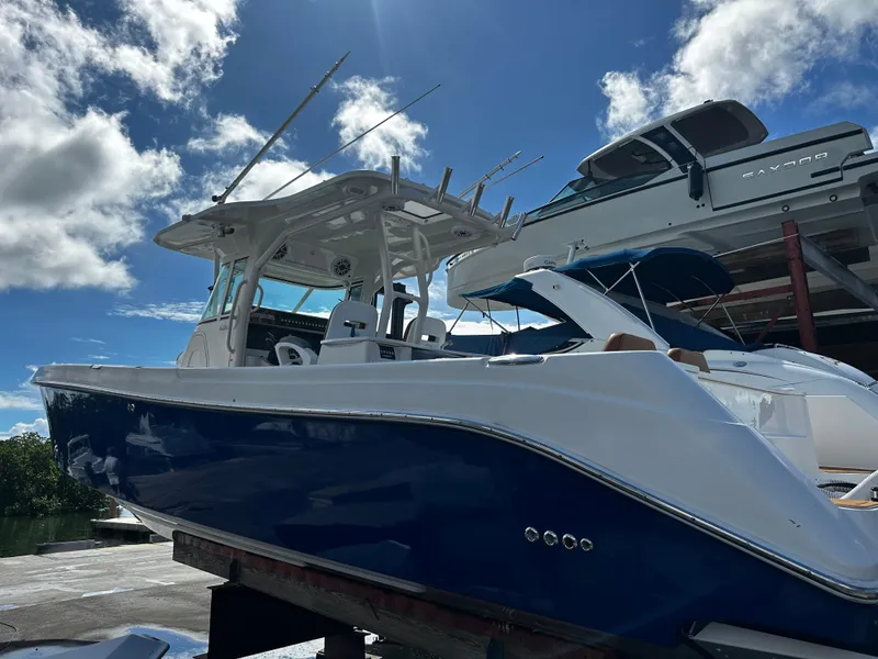 Slide: The Image of 2008 Everglades 350 CC boat with blue hull docked under a sunny sky. - 3