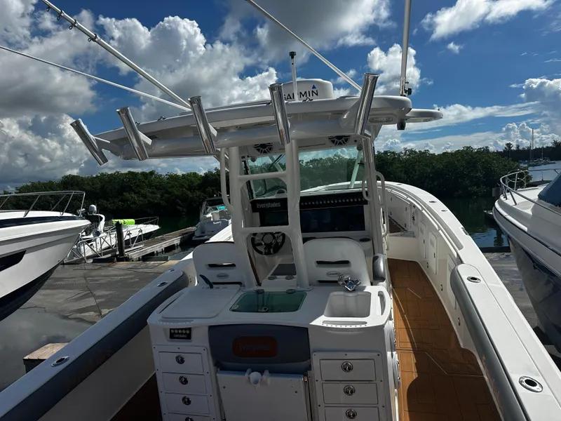 Slide: The Image of 2008 Everglades 350 CC boat docked, featuring a spacious deck and modern controls. - 9