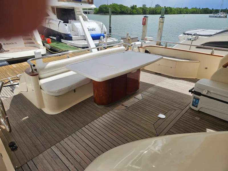 Slide: The Image of Astondoa 72 GLX yacht deck with seating and table, docked by the water. - 15