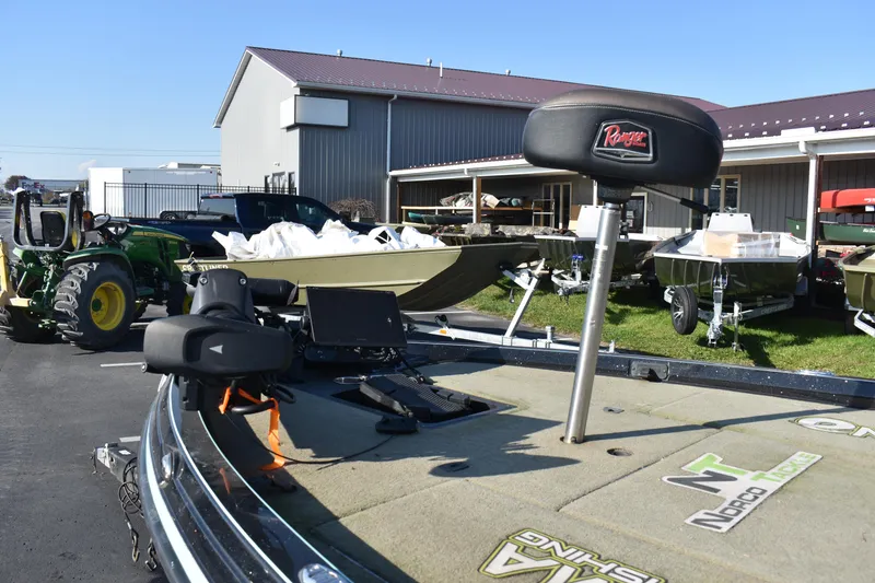Slide: The Image of 2019 Ranger Z521L fishing boat with equipment, parked near a tractor and storage buildings. - 7